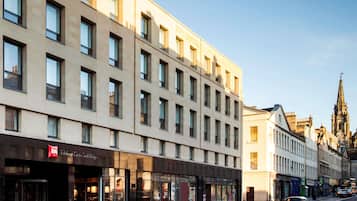 Un bâtiment moderne à la façade plate, doté de grandes fenêtres et d’une entrée imposante avec une enseigne.
