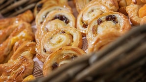 A variety of pastries, including cinnamon rolls and other baked goods, displayed on a table.