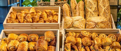 Une variété de produits de boulangerie est exposée, notamment des croissants et des baguettes.