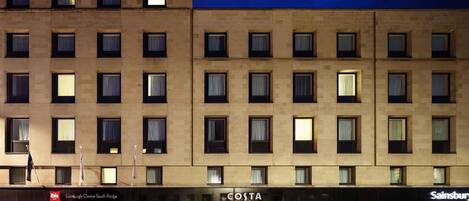 A multi-story building with a ground-floor retail space, including a Costa Coffee and a Sainsbury's store.