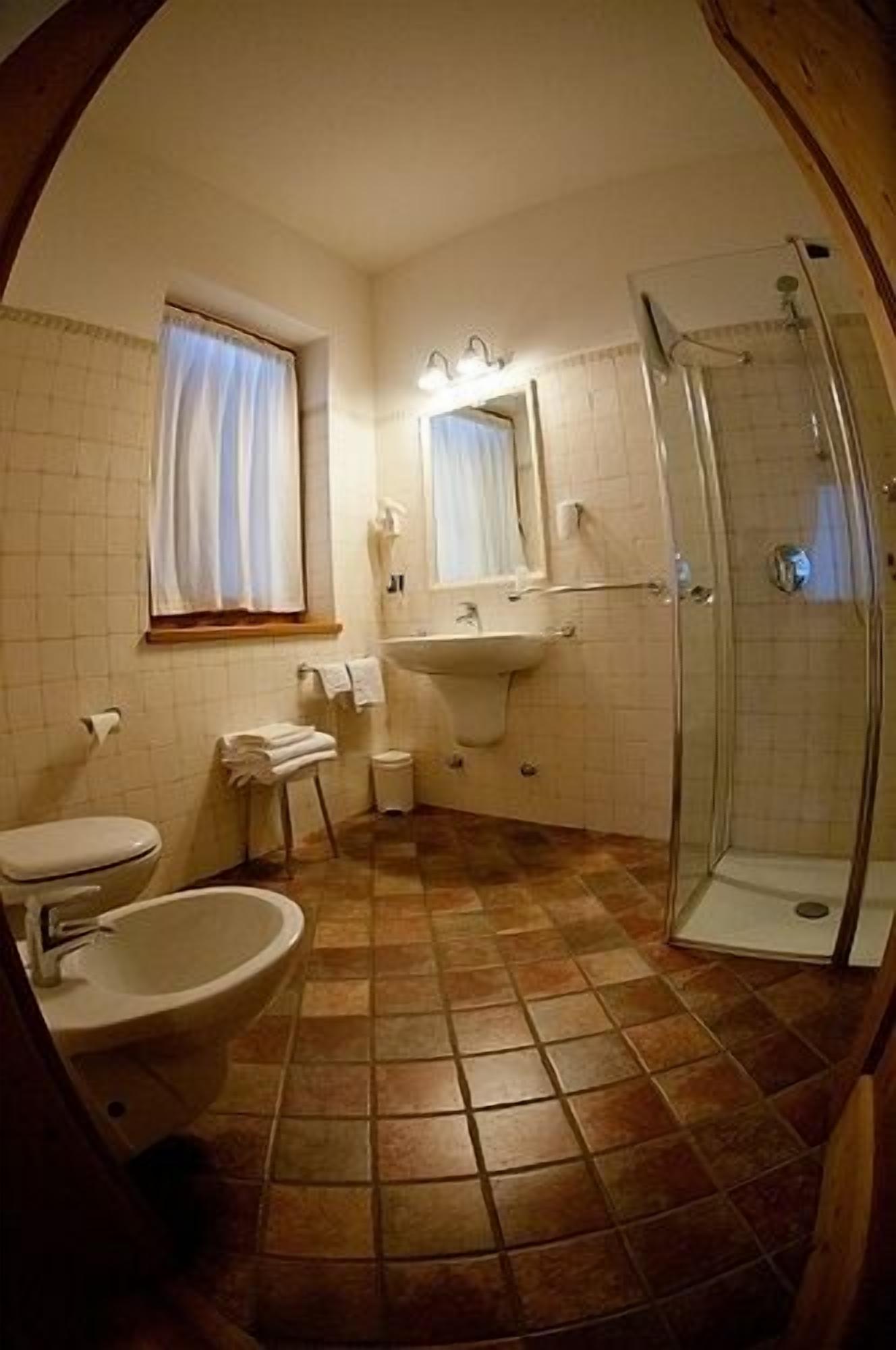 Un baño con inodoro, lavamanos y ducha.