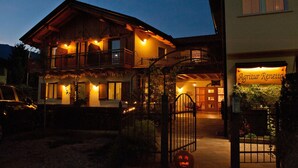 Een houten gebouw met twee verdiepingen, een balkon, een poort en een bord met de tekst 'Agritur Renetta'.