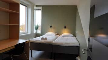 Cozy retreat with a single bed, desk, and storage.