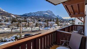 A balcony with a view of a snowy mountain town and a river. - Hotel da Beppe Sello (Cortina d'Ampezzo)