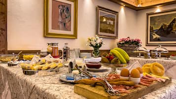 A buffet table with various food items and a floral centerpiece.