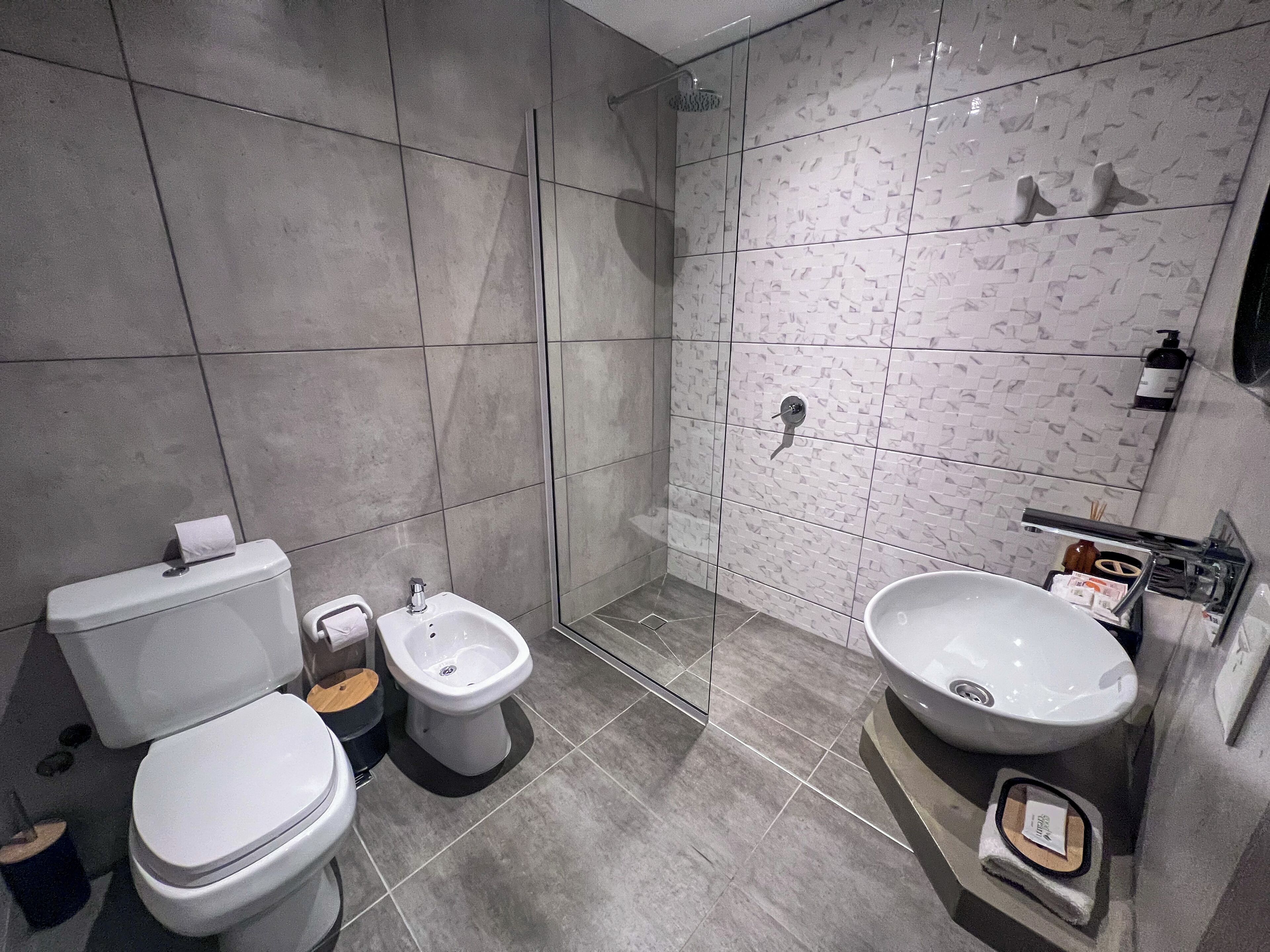A modern bathroom with a toilet, bidet, and sink.