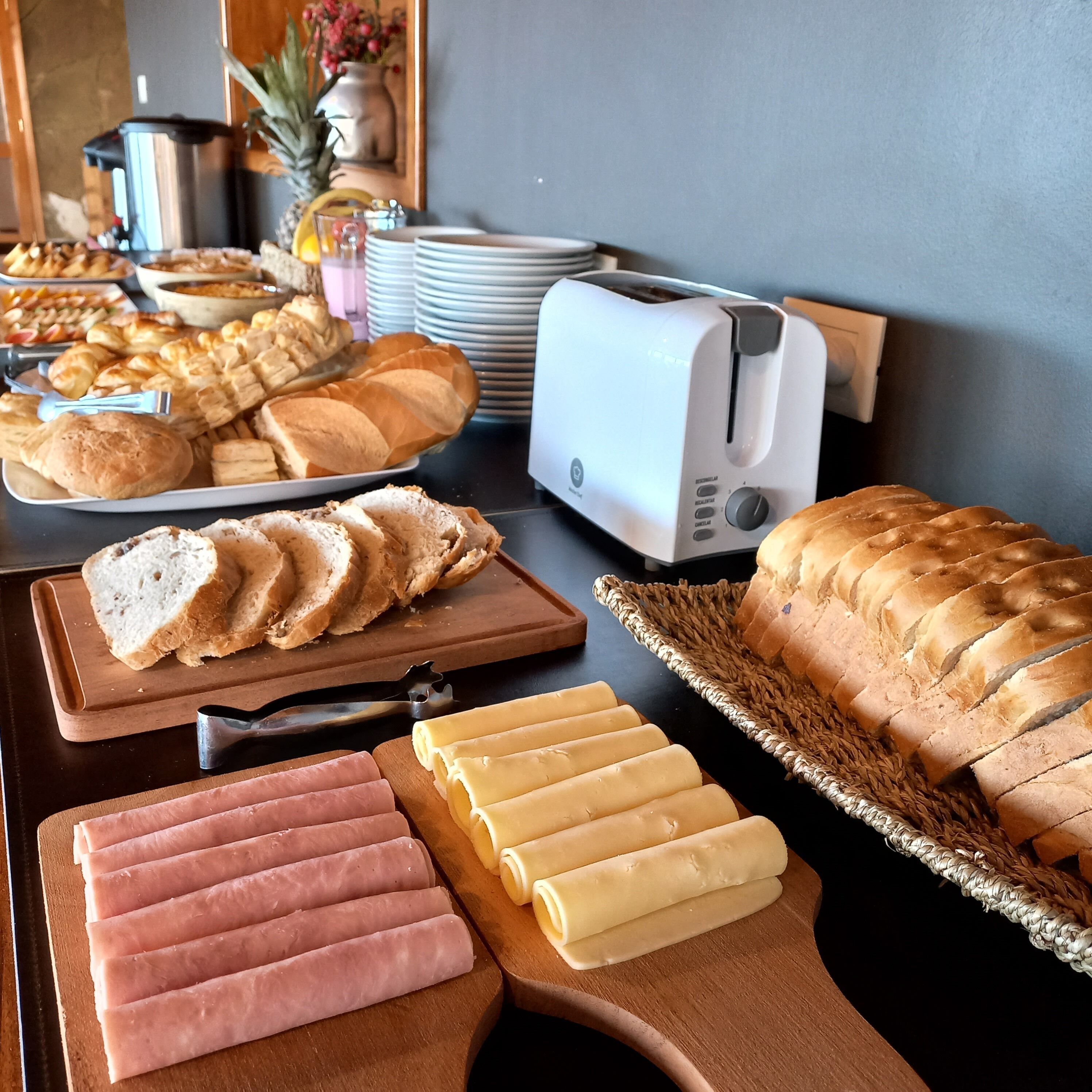 En morgenmadsbuffet med forskellige brød, kager og pålæg.