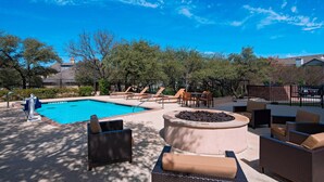 A pool area with lounge chairs, a hot tub, and a fire pit. - Fairfield Inn & Suites by Marriott Austin Northwest/Research Blvd (Austin)