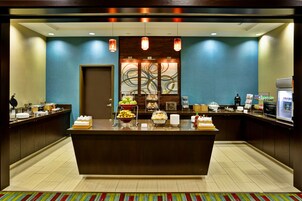 A reception area with a central counter, a coffee machine, and a microwave.