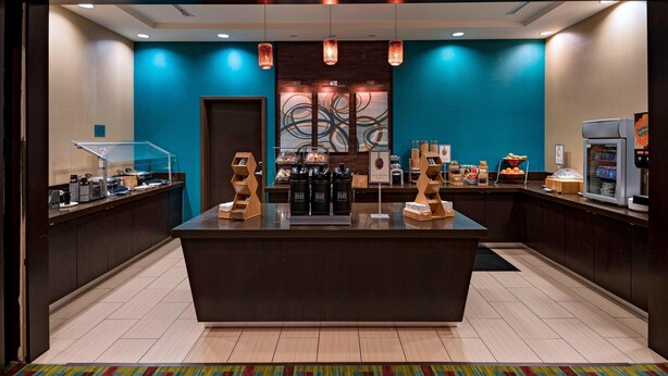A hotel lobby with a central island counter, coffee machines, and a refrigerator. - Fairfield Inn & Suites by Marriott Austin Northwest/Research Blvd (Austin)