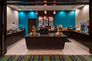A hotel lobby with a central island counter, coffee machines, and a refrigerator. - Fairfield Inn & Suites by Marriott Austin Northwest/Research Blvd (Austin)