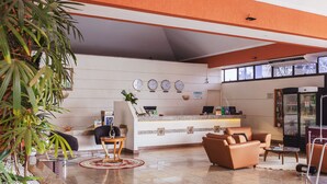 Un hall con mostrador de recepción, zona de estar y refrigerador.