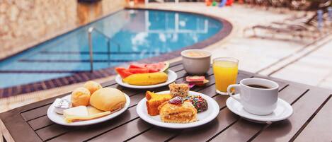 Una piscina al aire libre, sillones reclinables de piscina