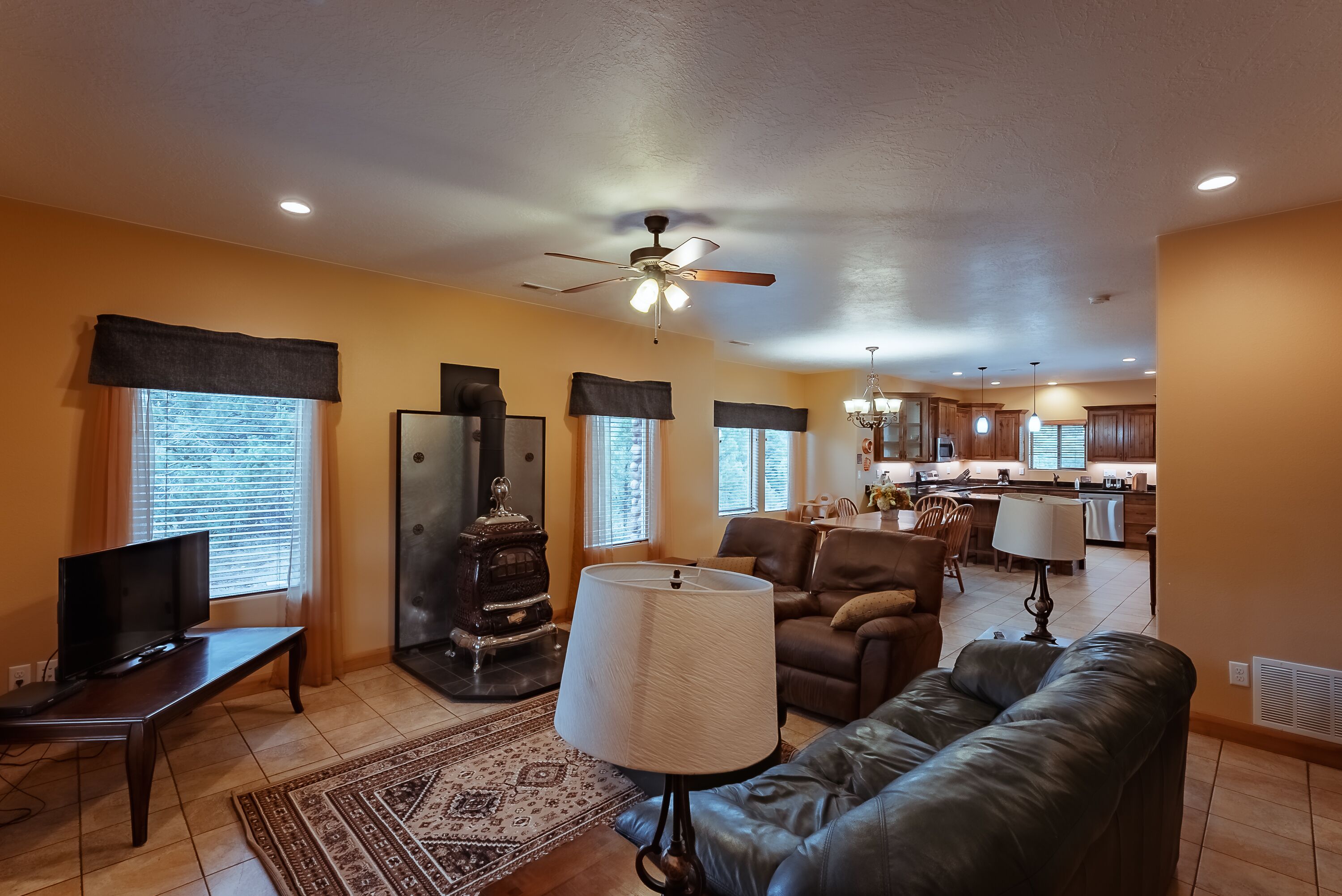 A living room with a fireplace, sofa, and television.