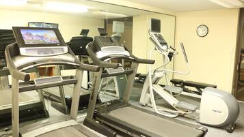 A gym with treadmills, ellipticals, and a stationary bike.