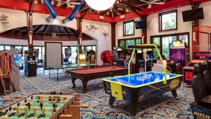 A room with a pool table, foosball table, and various arcade games. - Ramada by Wyndham Alpena (Alpena)