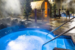 A hot tub with a wooden barrel structure, a pool, and a waterfall feature. - Hotel Marshfield, BW Premier Collection (Marshfield)