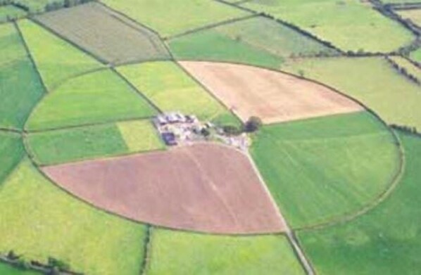 An aerial view of a farm with distinct fields and a small cluster of buildings. - The Ring Farmhouse (Birr)