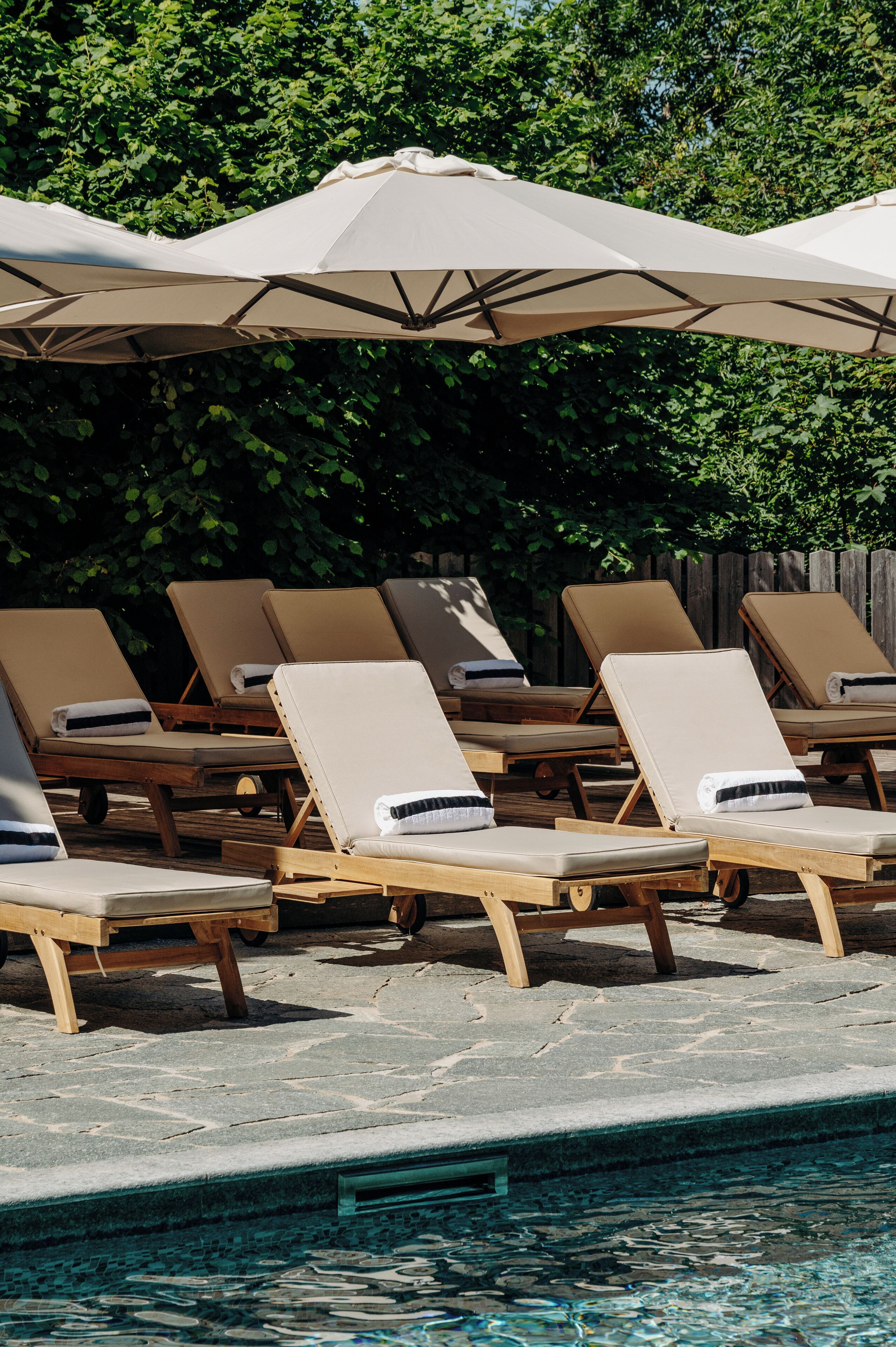 A poolside area with lounge chairs and umbrellas.