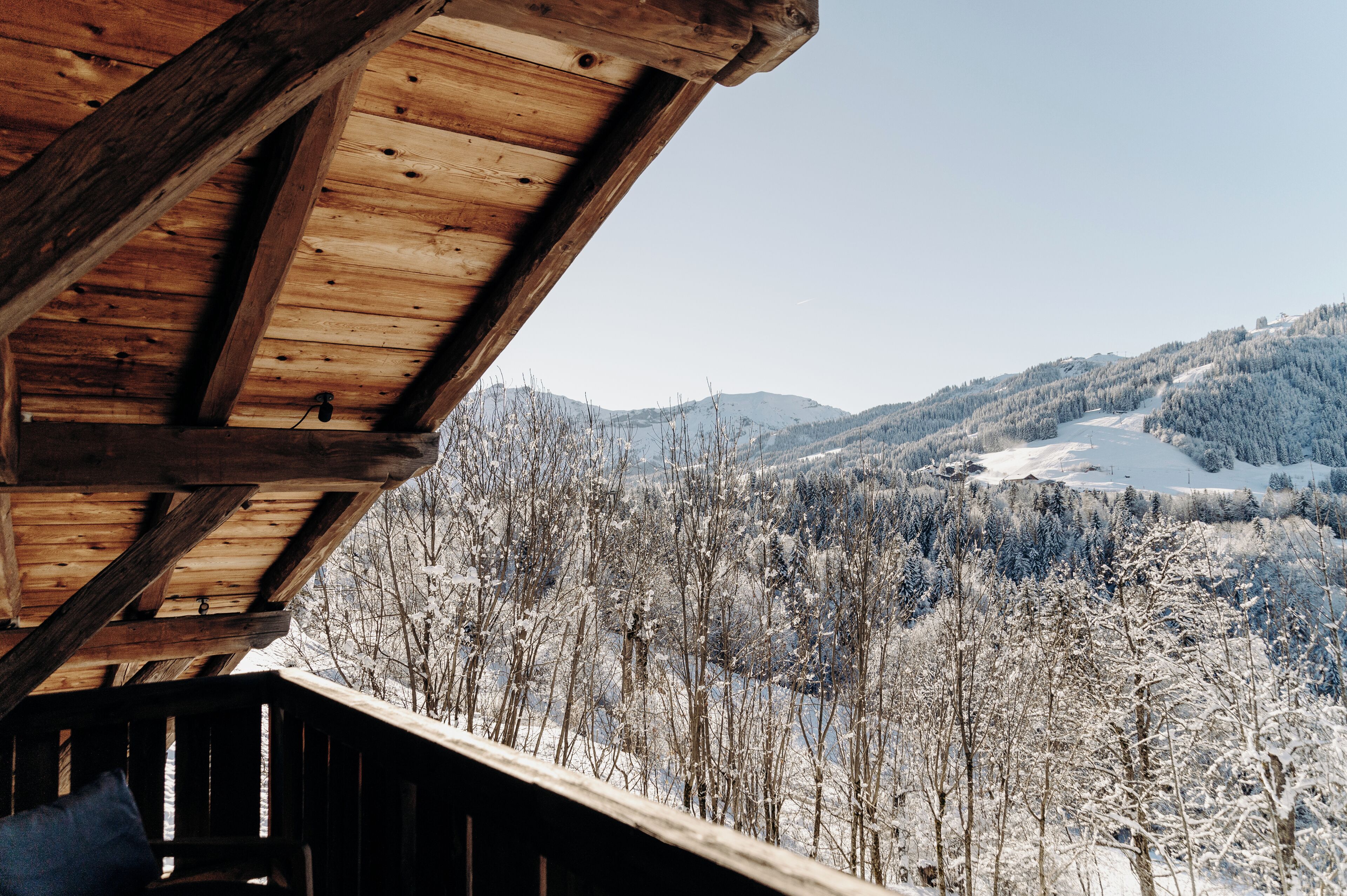 Uma cabana de madeira com vista para uma paisagem montanhosa coberta de neve.