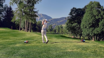 Golfers can enjoy a scenic round amidst well-manicured greens and distant mountains.