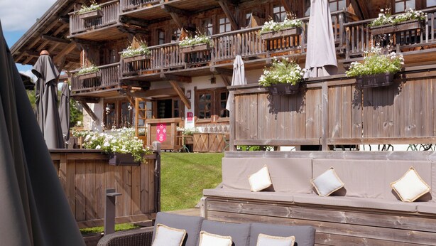 A wooden chalet with outdoor seating and flower boxes. - La Ferme du Golf (Megeve)
