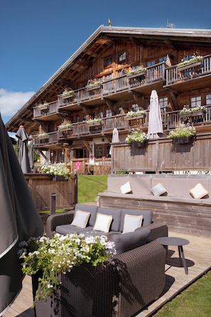 A wooden chalet with outdoor seating and flower boxes. - La Ferme du Golf (Megeve)