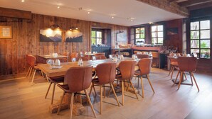 A restaurant with wooden walls, large windows, and a bar area. - La Ferme du Golf (Megeve)