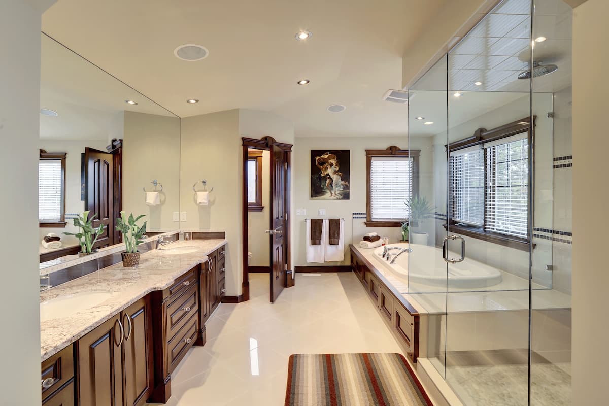 A spacious bathroom with a large vanity, a glass shower enclosure, and a walk-in shower.
