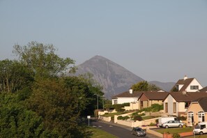 A residential street with houses, a mountain in the background, and a clear sky. - Brooklodge B&B (Westport)