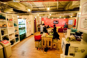 A communal dining area with a vending machine, a television, and a Christmas tree.