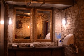 A bathroom with two large mirrors, a sink with a hairdryer, and a wall-mounted light fixture. - Triangel Guesthouse Hongdae (Seoul)