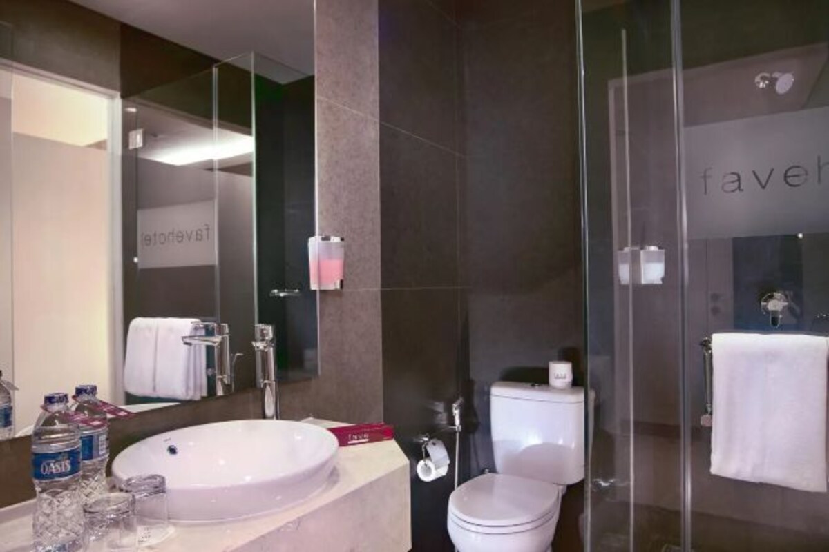Une salle de bain moderne avec un grand lavabo ovale, des toilettes et une douche à parois de verre.