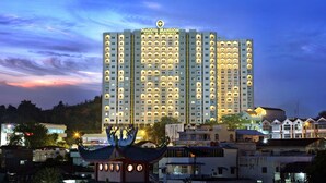 Een meerhoog hotel met een opvallend bord waarop staat: Nagoya Mansion Hotel & Residence.