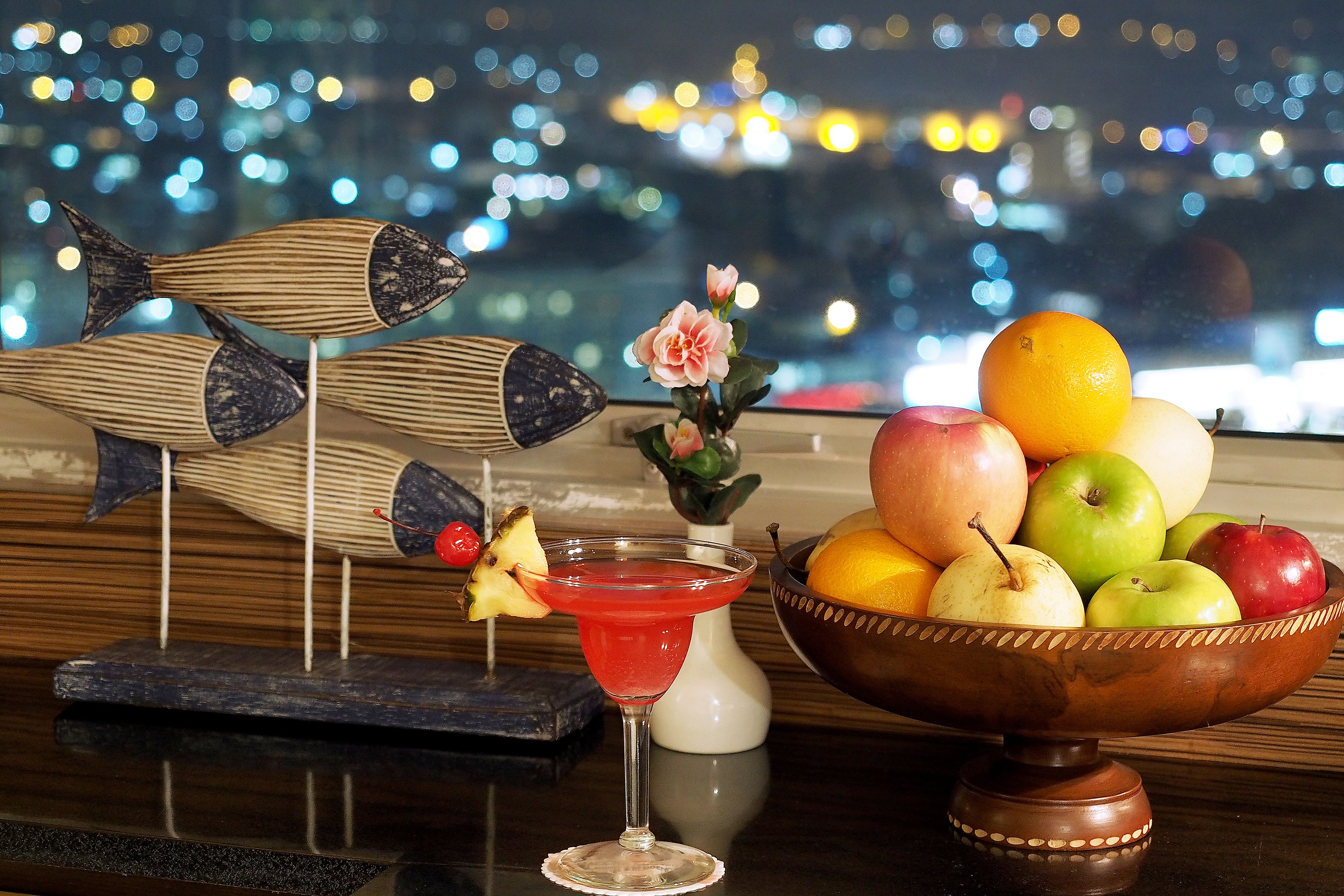 Eine Bar mit Martini-Glas, Obstschale und dekorativen Fischskulpturen.