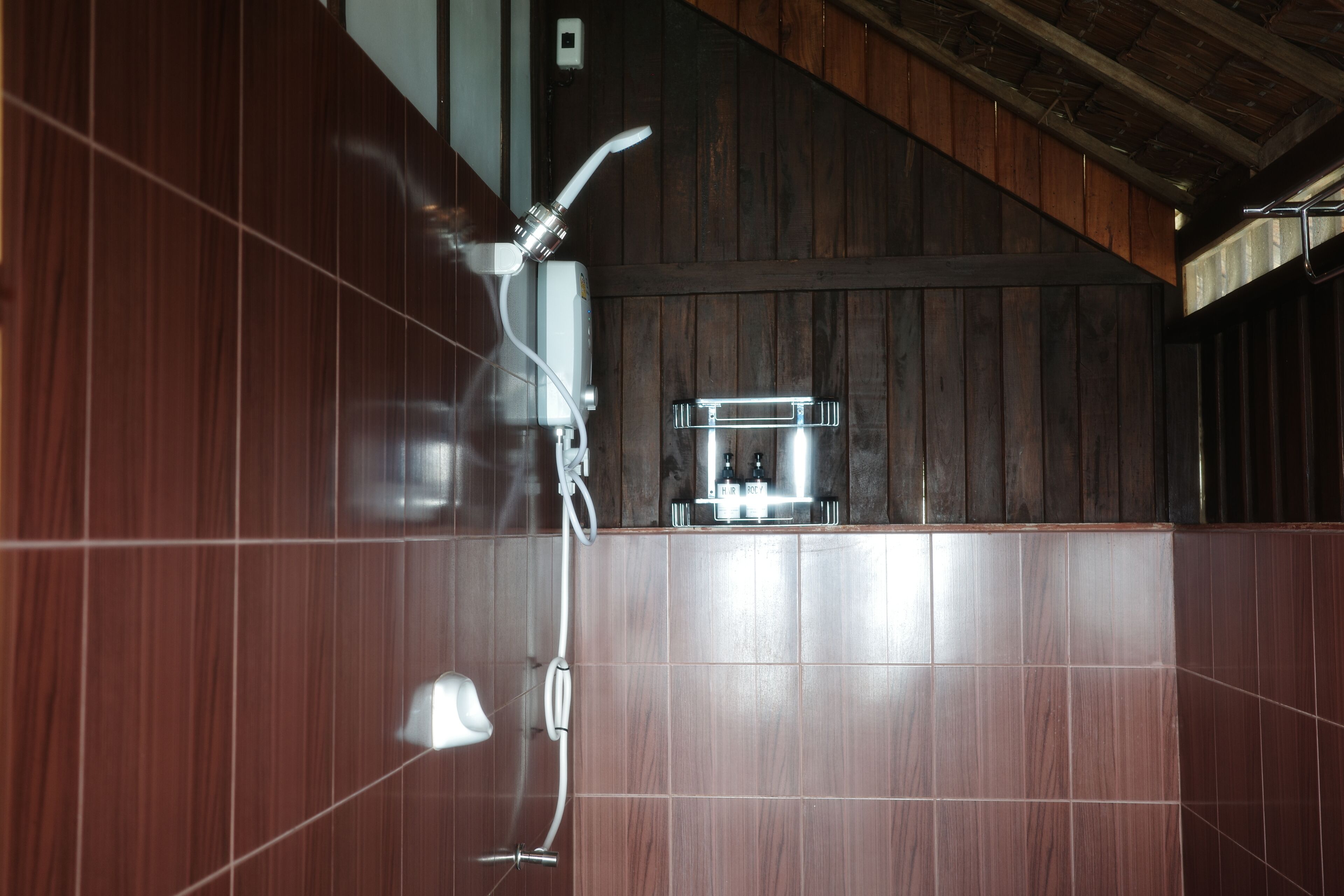 Un baño con paredes de madera y una zona de ducha.