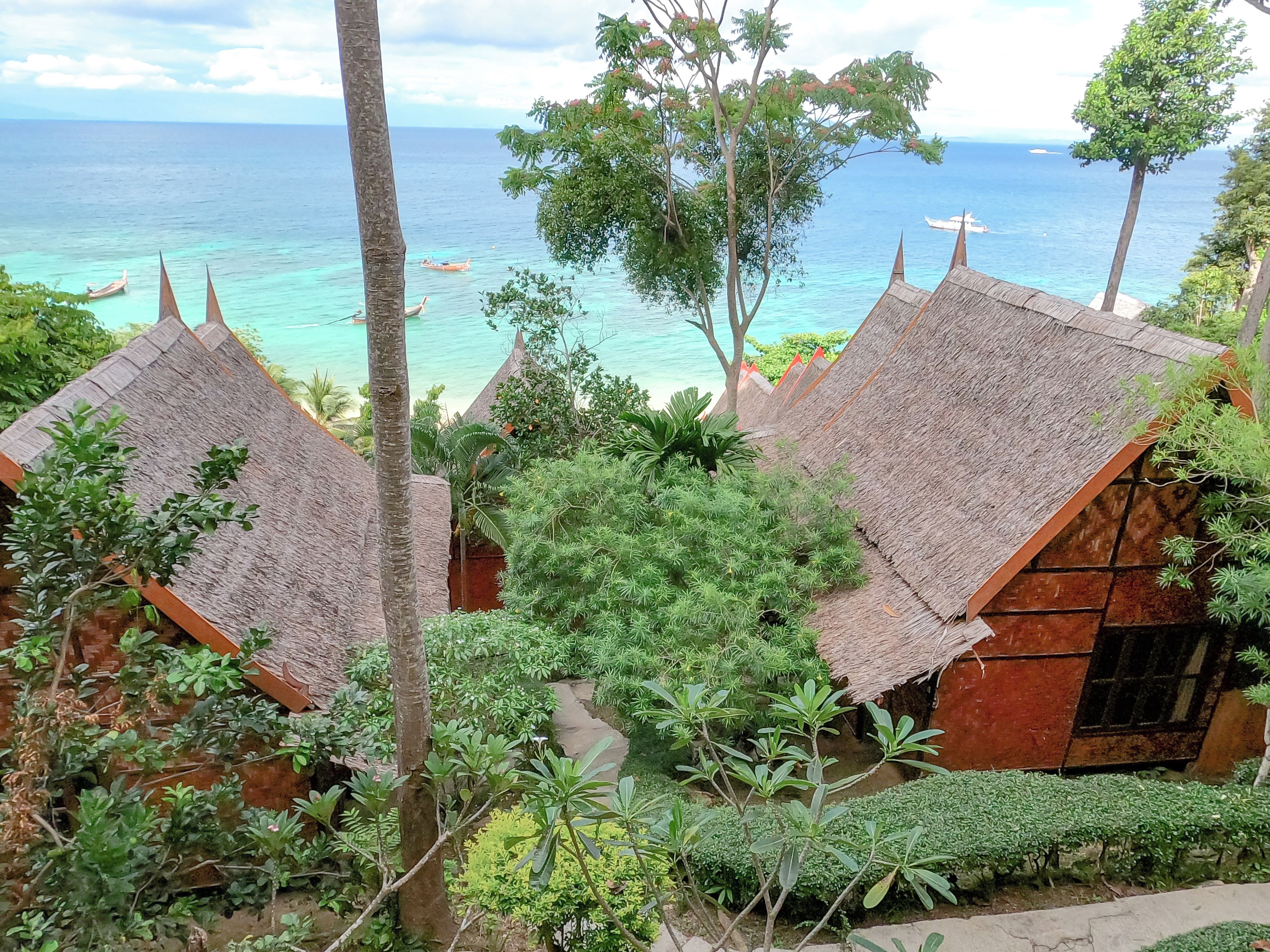 A traditional thatched-roof building with a view of the ocean.