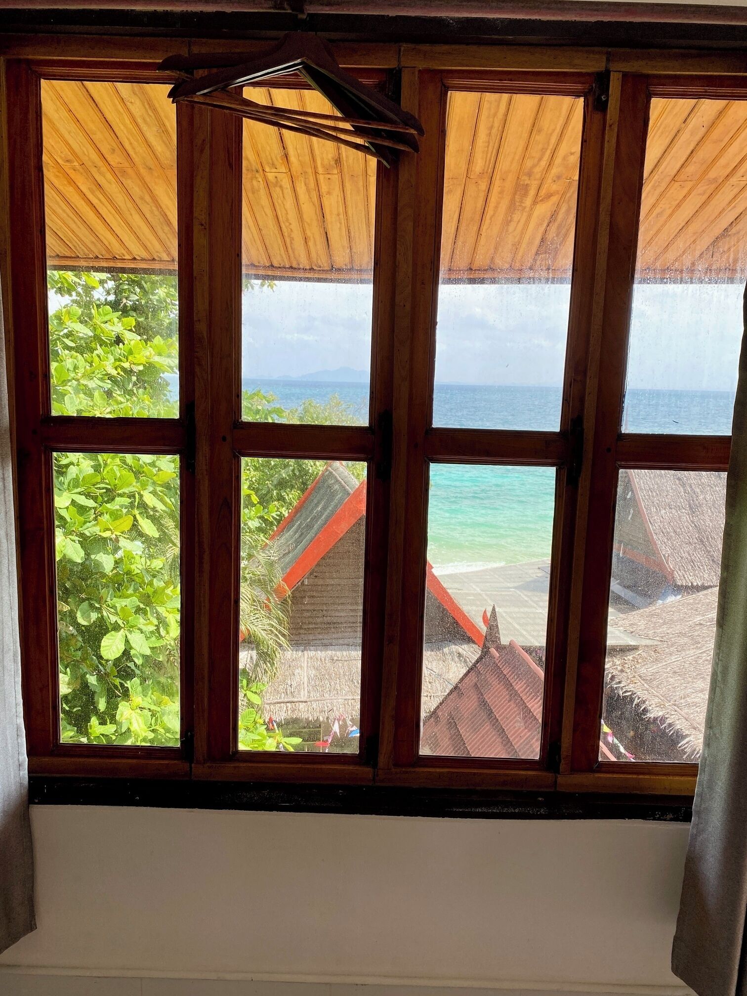 A window with a view of a beach and buildings.