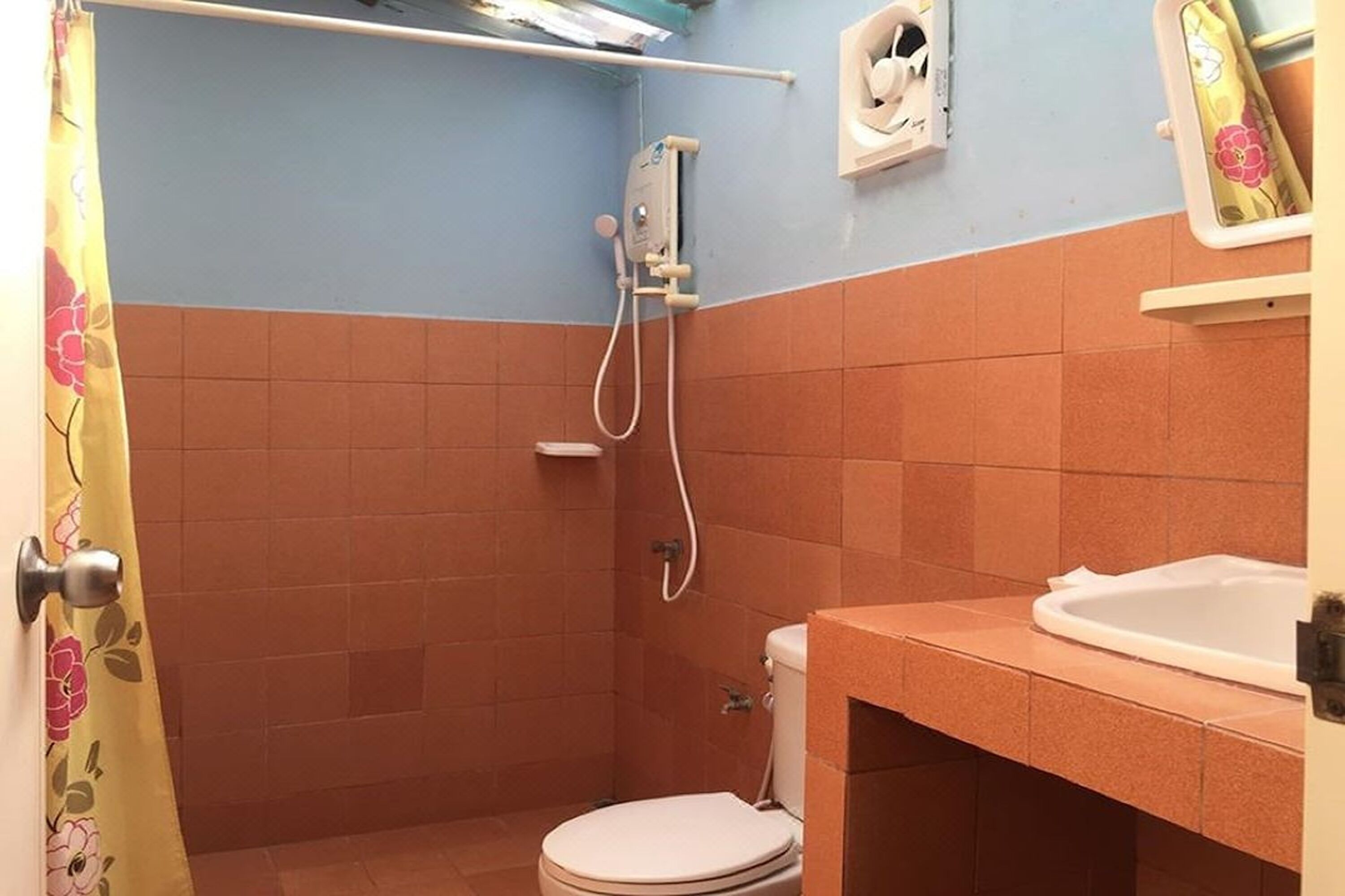 Un baño pequeño con ducha, inodoro y lavabo.