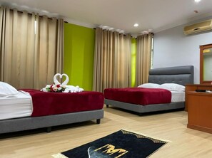 Une chambre d’hôtel avec deux lits, un bureau et un grand miroir.