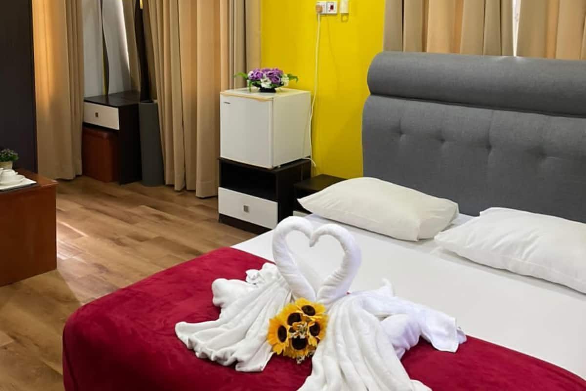 Ein Hotelzimmer mit Bett, Schreibtisch, Fernseher und Nachttisch.