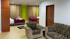 A hotel room with two beds, a sofa, a wooden wardrobe, and a door. - Samudera Hotel (Kuala Besut)