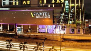 A hotel with a modern design, featuring a prominent curved glass facade and illuminated windows. - Vivatel Kuala Lumpur (Kuala Lumpur)