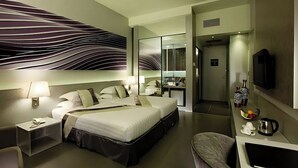 A modern hotel room with a large bed, bedside tables, a desk, a chair, a TV, and a bathroom visible through a glass door. - Vivatel Kuala Lumpur (Kuala Lumpur)