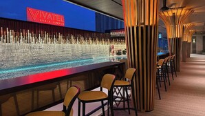 A modern bar area with a Vivatel Kuala Lumpur sign, wooden pillars, and bar stools. - Vivatel Kuala Lumpur (Kuala Lumpur)