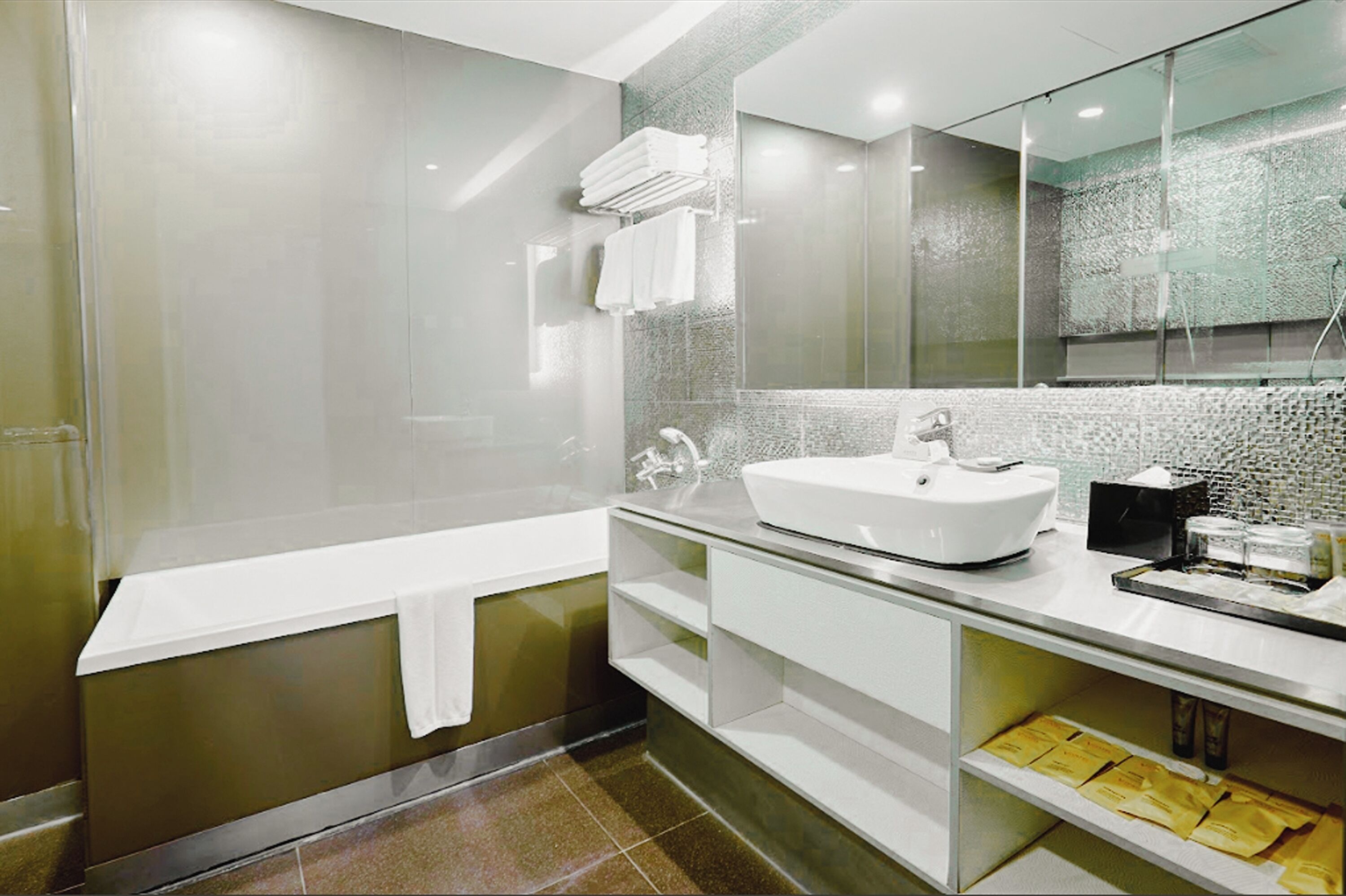 A modern bathroom with a glass shower enclosure, a white sink, and a large mirror.