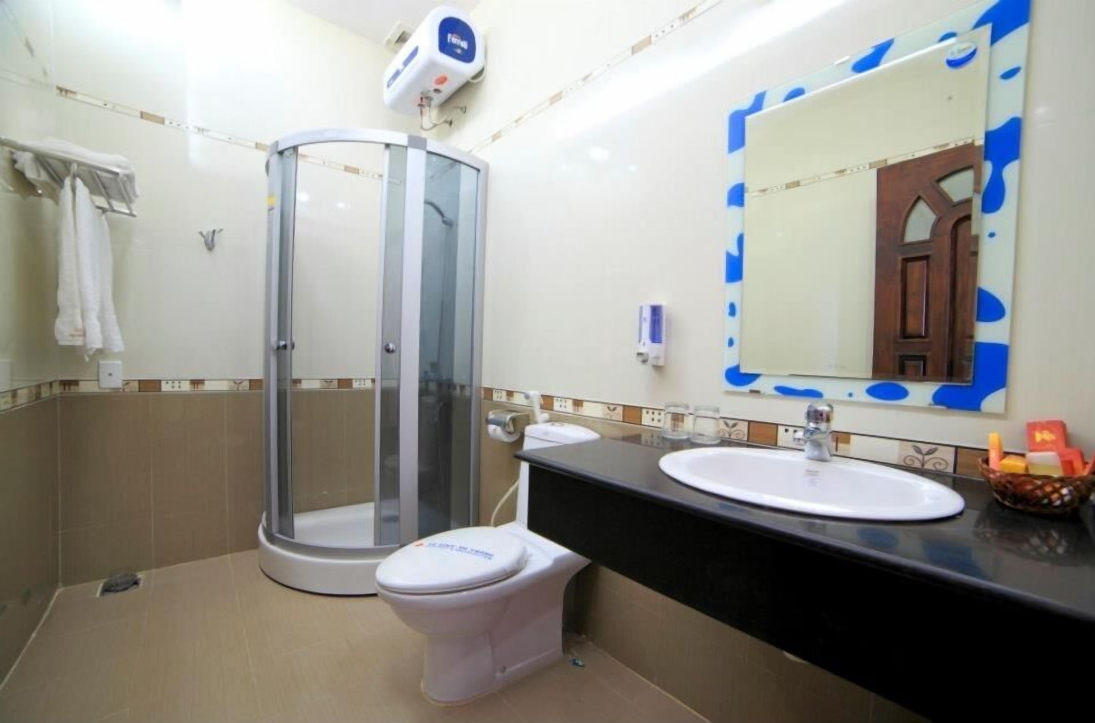 A bathroom with a glass-enclosed shower, a white toilet, a sink with a mirror, and a towel rack.