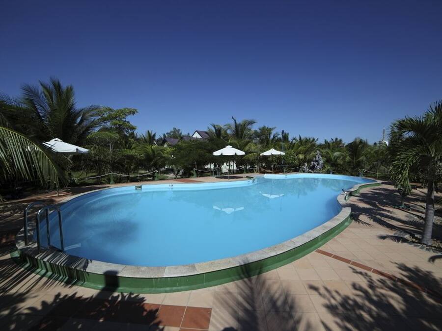 Una piscina al aire libre, sombrillas, tumbonas