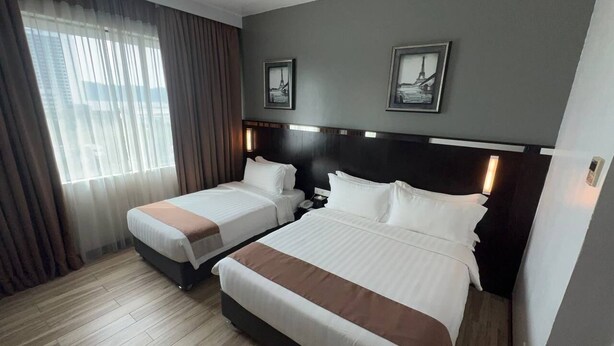 A hotel room with two beds, a large window with curtains, and two framed pictures on the wall. - Dreamtel Kota Kinabalu (Kota Kinabalu)