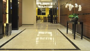 A modern hotel lobby with a polished marble floor, recessed lighting, and a reception area in the background. - Dreamtel Kota Kinabalu (Kota Kinabalu)